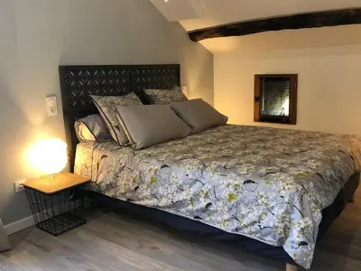 a bedroom with a bed and a lamp on a table at Appartements de Charme in Corte