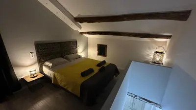 a small bedroom with a bed with a yellow blanket at Appartements de Charme in Corte