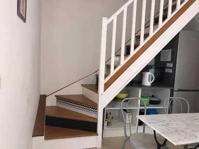 a white staircase in a kitchen with a table at Appartements de Charme in Corte