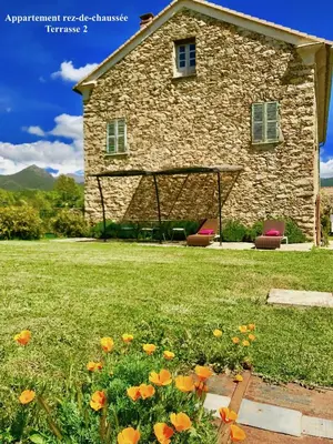 a stone house with flowers in front of it at Appartements de Charme in Corte