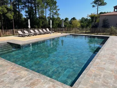 a swimming pool with chairs and a swimming pool at Domaine de Pianiccia in Favone