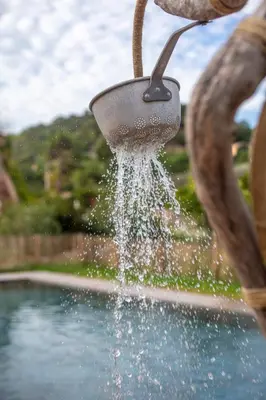 a person is pouring water into a fountain at Domaine de Pianiccia in Favone