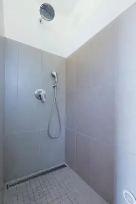 a shower with a shower head in a bathroom at Domaine de Pianiccia in Favone