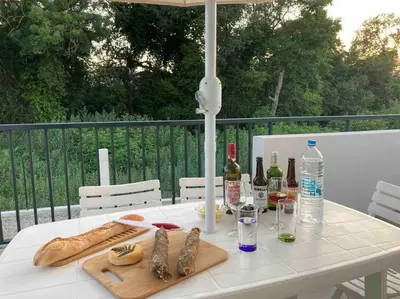 a white table with bottles of wine and bread on it at Villa mina in Ghisonaccia