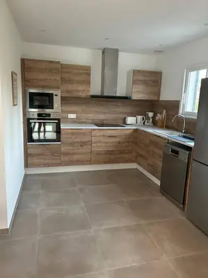 a large kitchen with wooden cabinets and appliances at Villa mina in Ghisonaccia
