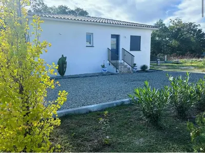 a small white house with a gravel yard at Villa mina in Ghisonaccia