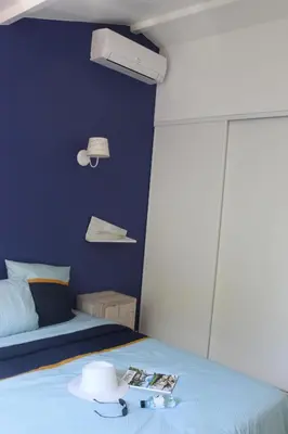 a blue bedroom with a bed with a hat on it at CASA PALOMBAGGIA - Piscine Chauffée in Porto-Vecchio