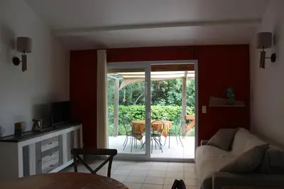 a living room with a couch and a sliding glass door at CASA PALOMBAGGIA - Piscine Chauffée in Porto-Vecchio