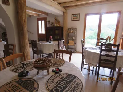 a dining room with tables and chairs and a room with windows at l'altore di savaghju in Vivario