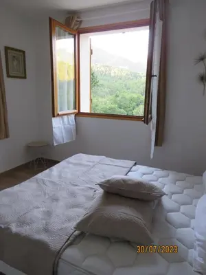 a bedroom with a large bed with a window at l'altore di savaghju in Vivario