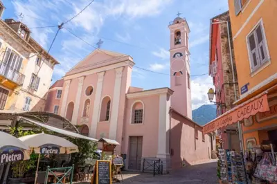 a church with a clock tower in a street at Corte magnifique T2 45m2 neuf 5 personnes place st marcel hyper centre wifi lave linge tv in Corte