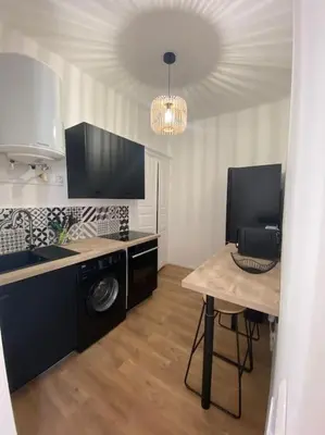 a room with a kitchen with a table and a microwave at Corte magnifique T2 45m2 neuf 5 personnes place st marcel hyper centre wifi lave linge tv in Corte