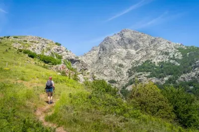 a person walking on a trail in the mountains at Corte magnifique T2 45m2 neuf 5 personnes place st marcel hyper centre wifi lave linge tv in Corte