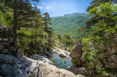 two people swimming in a river in the mountains at Corte magnifique T2 45m2 neuf 5 personnes place st marcel hyper centre wifi lave linge tv in Corte