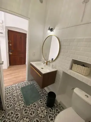 a bathroom with a sink and a mirror and a toilet at Corte magnifique T2 45m2 neuf 5 personnes place st marcel hyper centre wifi lave linge tv in Corte