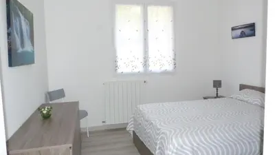 a bedroom with a bed and a desk and a window at U Sortipiani in Sortipiani