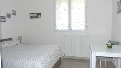 a white bedroom with a bed and a window at U Sortipiani in Sortipiani