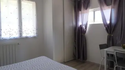 a bedroom with purple curtains and a bed and a window at U Sortipiani in Sortipiani