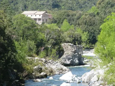 a house on a hill next to a river at U Sortipiani in Sortipiani