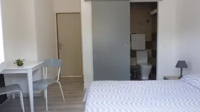 a bedroom with a bed and a desk and a table at U Sortipiani in Sortipiani