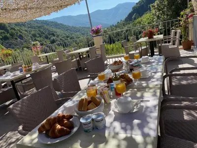a table with a breakfast of bread and orange juice at U Sortipiani in Sortipiani
