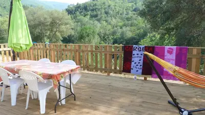 a hammock and a table and chairs on a deck at U Sortipiani in Sortipiani