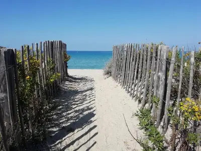 a wooden fence on the beach next to the ocean at A Torra in Ville-di-Paraso