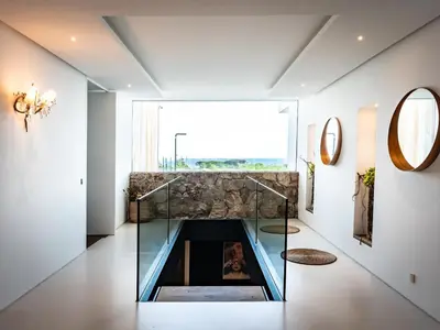 a glass fireplace in a living room with a window at Villa AzaiTu Suites in Porto-Vecchio