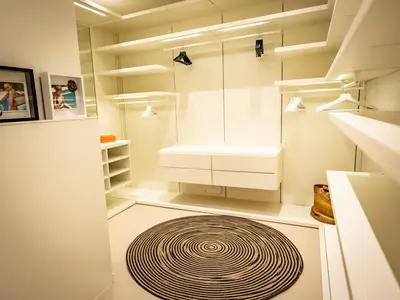 a kitchen with white cabinets and a large rug on the floor at Villa AzaiTu Suites in Porto-Vecchio