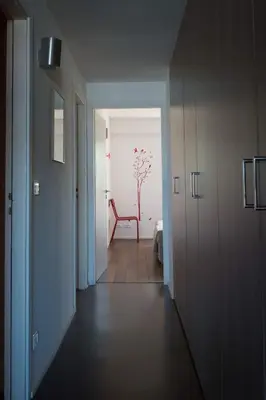 a hallway with a red chair in a room at Immeuble La Mer in Porto-Vecchio