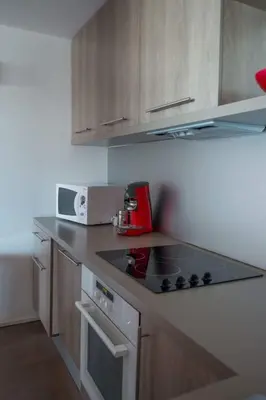 a kitchen with a stove and a microwave at Immeuble La Mer in Porto-Vecchio