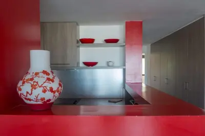 a vase sitting on a red counter in a kitchen at Immeuble La Mer in Porto-Vecchio
