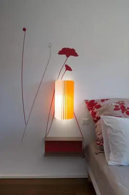 a lamp sitting on a wall next to a bed at Immeuble La Mer in Porto-Vecchio