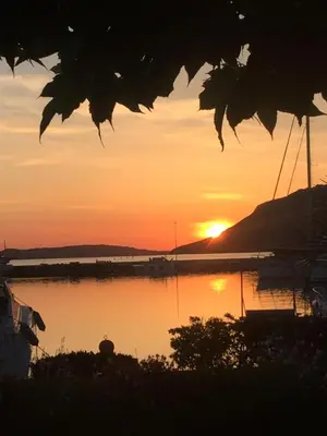 a sunset over a body of water with a boat at Immeuble La Mer in Porto-Vecchio