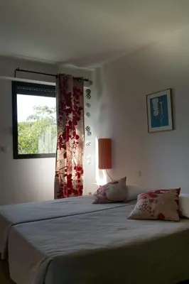 a bedroom with a large bed with a window at Immeuble La Mer in Porto-Vecchio