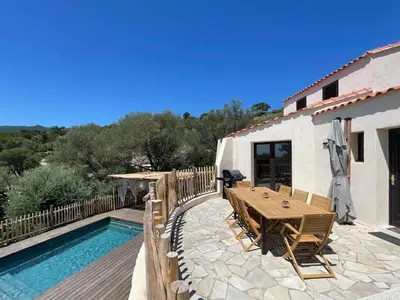a patio with a table and chairs next to a pool at Les Hauts de Capo - Domaine privé à proximité de Porto-Vecchio in Lecci