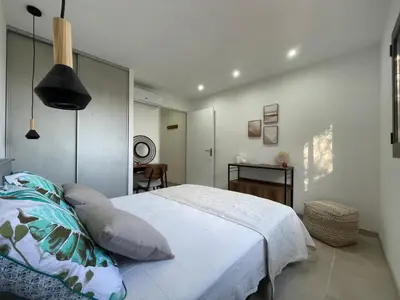a bedroom with a large white bed and a desk at Les Hauts de Capo - Domaine privé à proximité de Porto-Vecchio in Lecci