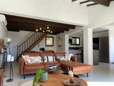 a living room with a couch and a table at Les Hauts de Capo - Domaine privé à proximité de Porto-Vecchio in Lecci