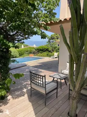 a bench and a table on a deck with a cactus at Villa Bianca - Vue imprenable Mer & Porto-Vecchio, Piscine chauffée à débordement, Accès privé plage in Porto-Vecchio