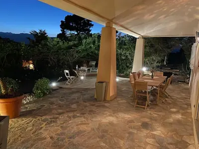 a patio with a table and chairs under a tent at Villa Bianca - Vue imprenable Mer & Porto-Vecchio, Piscine chauffée à débordement, Accès privé plage in Porto-Vecchio