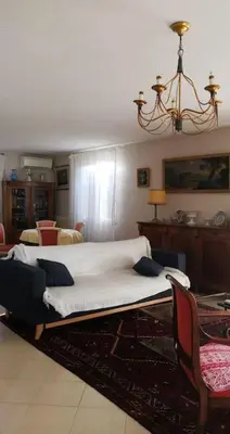 a bed in a living room with a chandelier at Mare è Monte , jardin méditerranéen et exotique. in Ghisonaccia