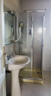 a bathroom with a glass shower and a sink at Mare è Monte , jardin méditerranéen et exotique. in Ghisonaccia