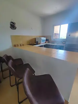 a kitchen with two bar stools and a counter at Havre de paix T3 vue mer in Conca