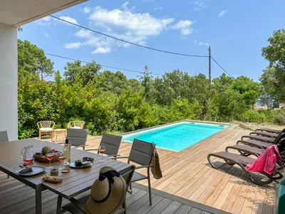 a patio with a table and chairs next to a swimming pool at Apartment Villa Kalliste by Interhome in Favone
