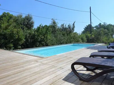 a swimming pool with chairs on a wooden deck at Apartment Villa Kalliste by Interhome in Favone