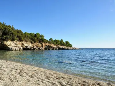 a beach with a rocky shore and the ocean at Apartment Villa Kalliste by Interhome in Favone