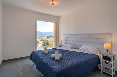 a bedroom with a large bed and a large window at Casa a cucina in Propriano
