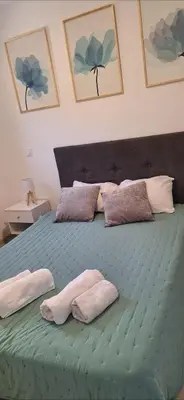 a bedroom with a green bed with two towels on it at Appartement climatisé Pinarello in Zonza