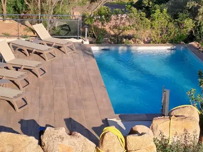 a swimming pool with lounge chairs and a swimming pool at Appartement climatisé Pinarello in Zonza