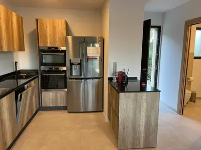 a kitchen with a stainless steel refrigerator and cabinets at Appartement climatisé Pinarello in Zonza